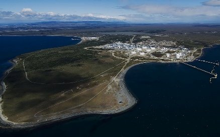 Aerial view of a deepwater port with industrial quayside facilities along a coastline.